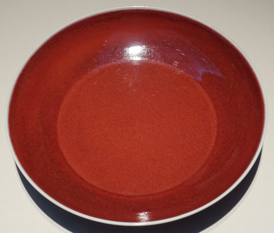 A porcelain dish with a deep, vivid copper-red glaze