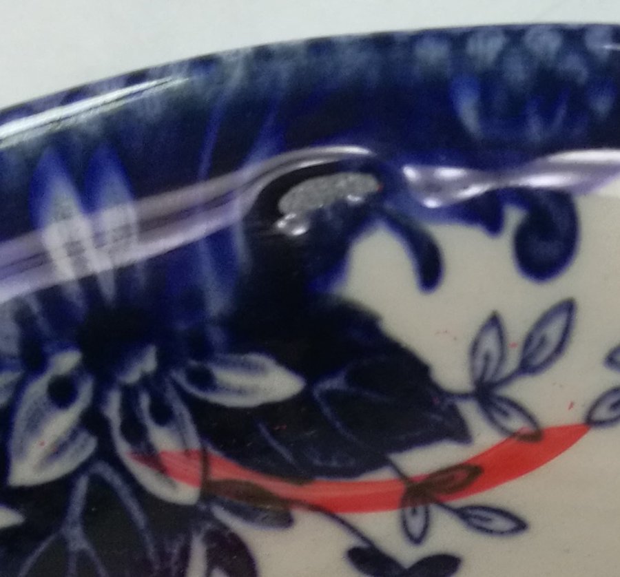 Close-up of a glazed rim where the glaze has pulled back during firing, leaving a bare patch of exposed body