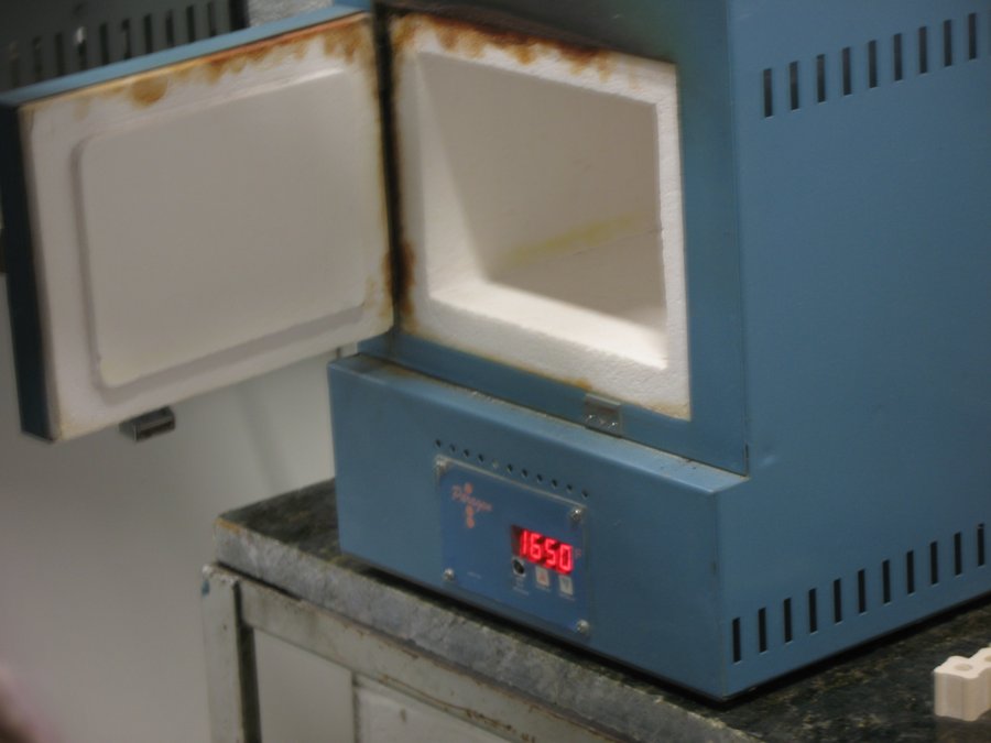 A small electric studio kiln with its door open, digital controller reading 1650°F