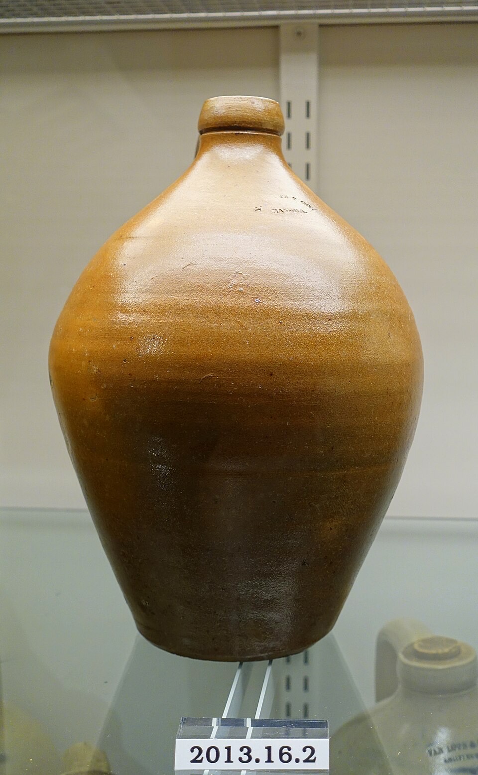 A tan-to-brown salt-glazed stoneware jug with mottled color variation from top to bottom