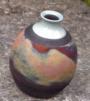 A raku-fired vase with smoky, crackled, metallic-colored surface effects
